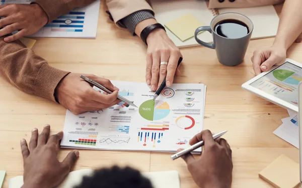 Equipo revisando informes y graficos sobre una mesa