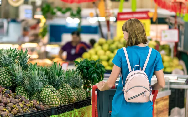 Clienta eligiendo producto en un puesto de mercado