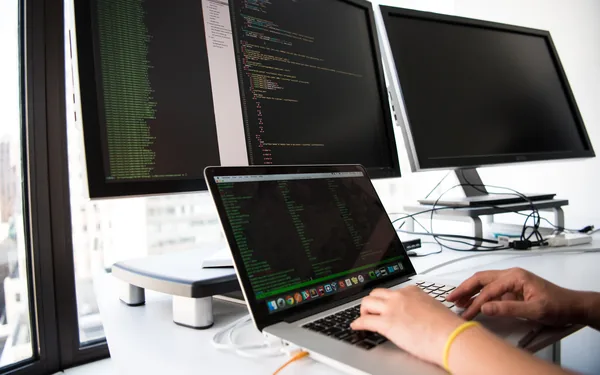 Puesto de trabajo con varias pantallas de codigo